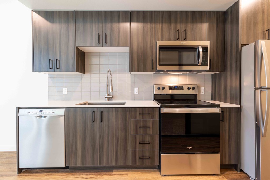 a modern kitchen with stainless steel appliances and wooden cabinets  at Rivulet, Silverdale, Washington