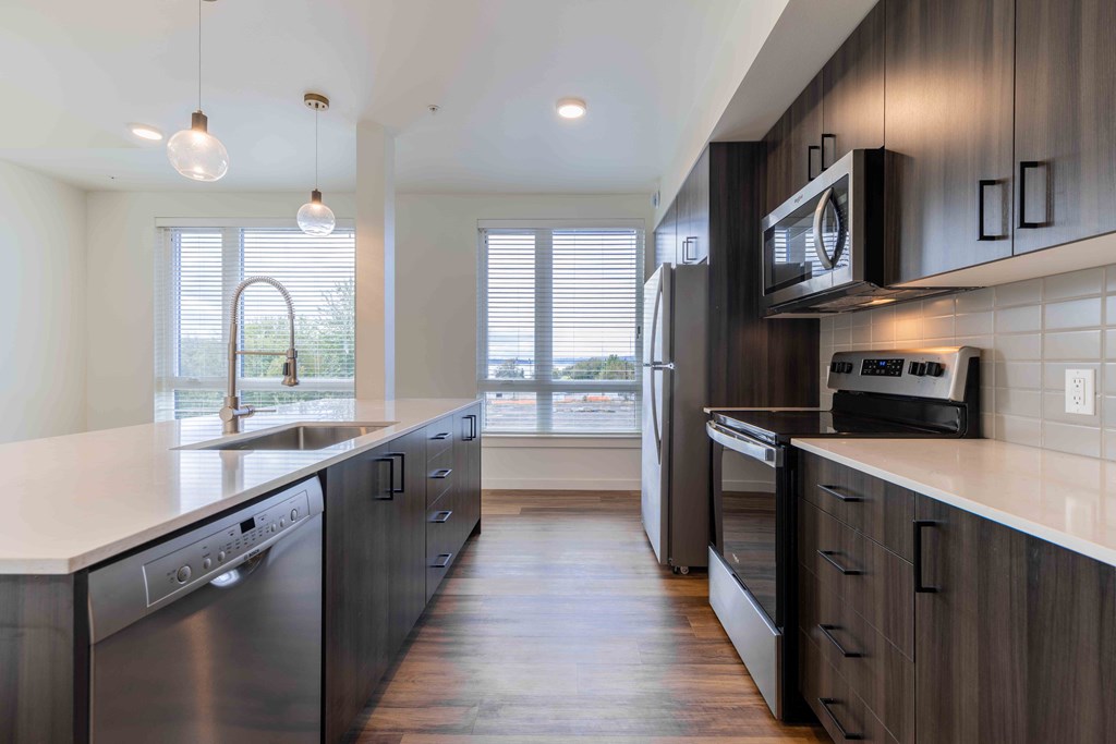 a large kitchen with stainless steel appliances and wooden cabinets  at Rivulet, Silverdale, Washington