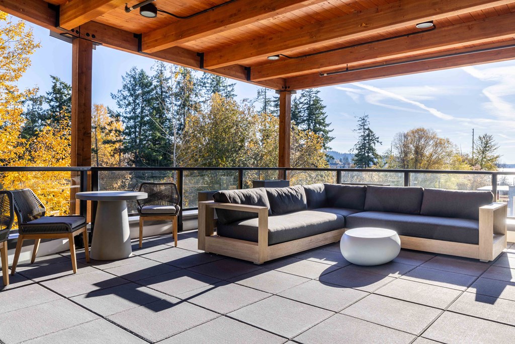 a patio with a couch and tables on a roof at Rivulet, Silverdale, WA
