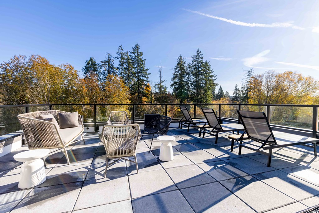 a patio with chairs and tables on a balcony at Rivulet, Silverdale, WA