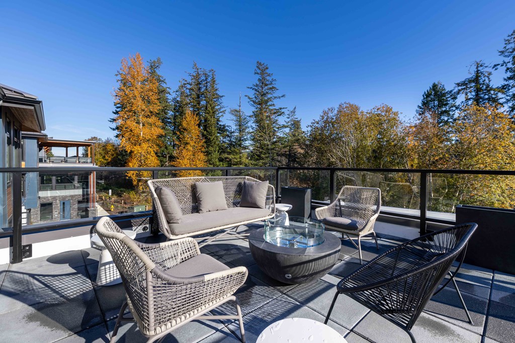 a patio with chairs and a glass table on a balcony at Rivulet, Silverdale