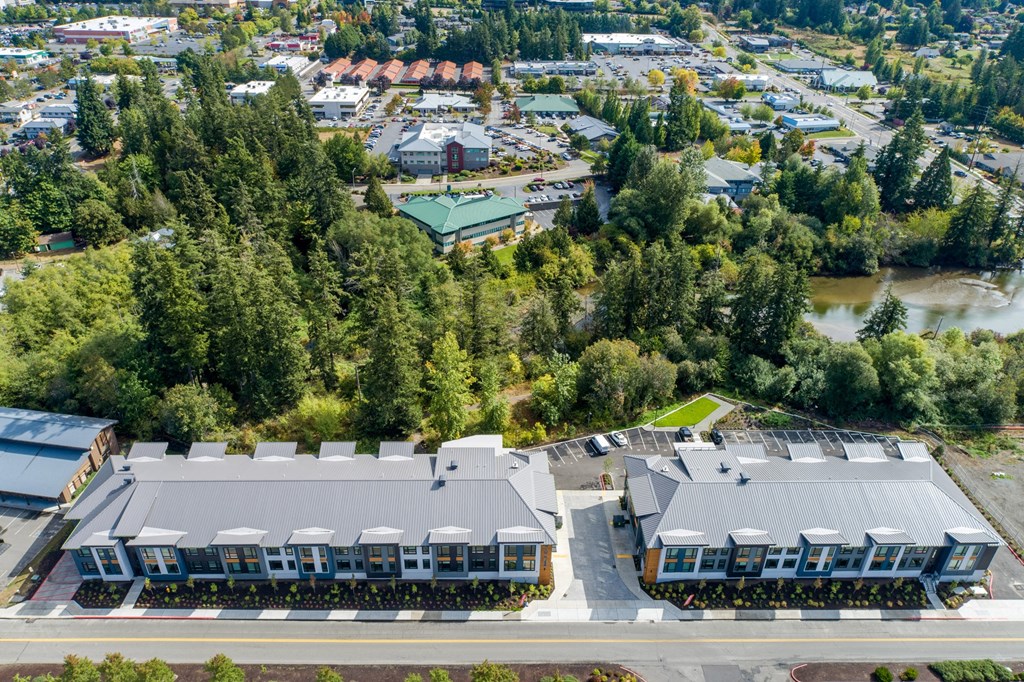 an aerial view of a building surrounded by trees and a river at Rivulet, Silverdale, 98383