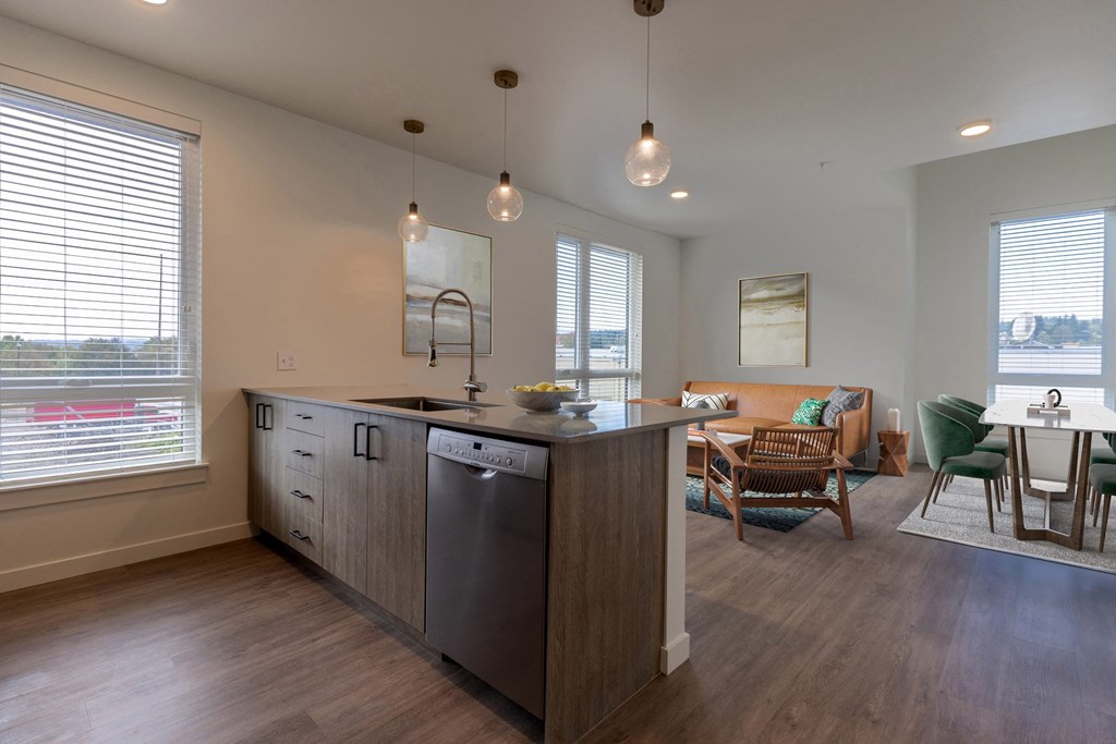 a kitchen with an island and a living room with a table and chairs at Rivulet, Silverdale, WA