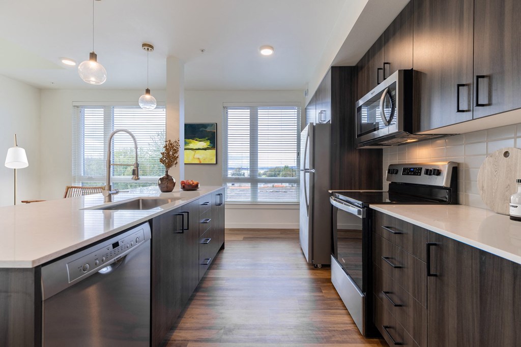a kitchen with stainless steel appliances and wooden cabinets at Rivulet, Silverdale, 98383