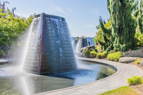 A water fountain in a garden with a clear blue sky at Spyglass Hill Apartments, Bremerton, 98337
