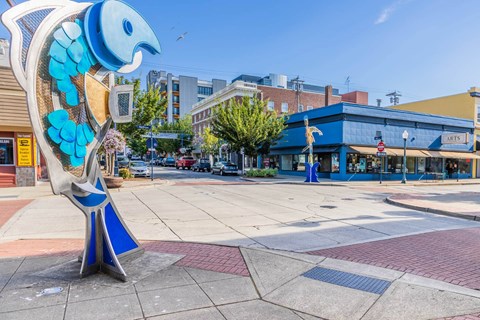 A blue and white bird sculpture is in the foreground of a city square  at Spyglass Hill Apartments, Bremerton, 98337