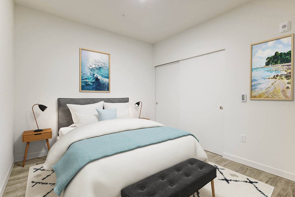 a bedroom with a large bed and two paintings on the wall