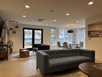A living room with a grey couch and a wooden table  at Spyglass Hill Apartments, Bremerton, 98337