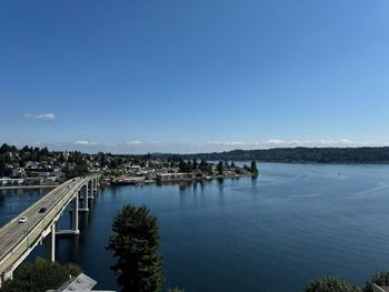 A bridge over a calm body of water with a city in the background  at Spyglass Hill Apartments, Bremerton, 98337