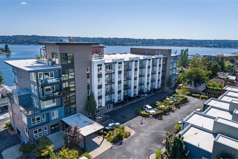 an aerial view of an apartment building with a lake in the background at Spyglass Hill Apartments, Washington 98337