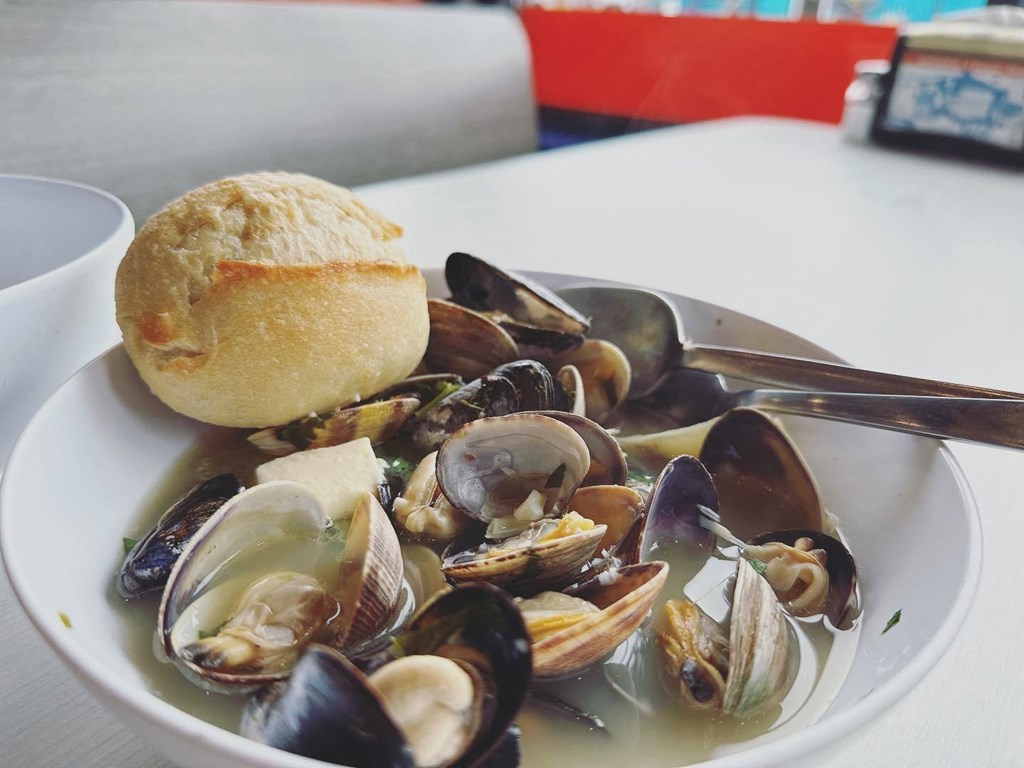 a bowl of clams and mussels with a roll on the side at Rivulet, Silverdale, WA