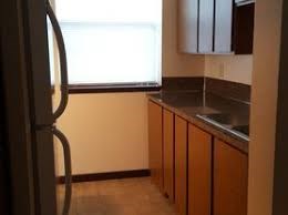 A kitchen with wooden cabinets and a stainless steel sink.