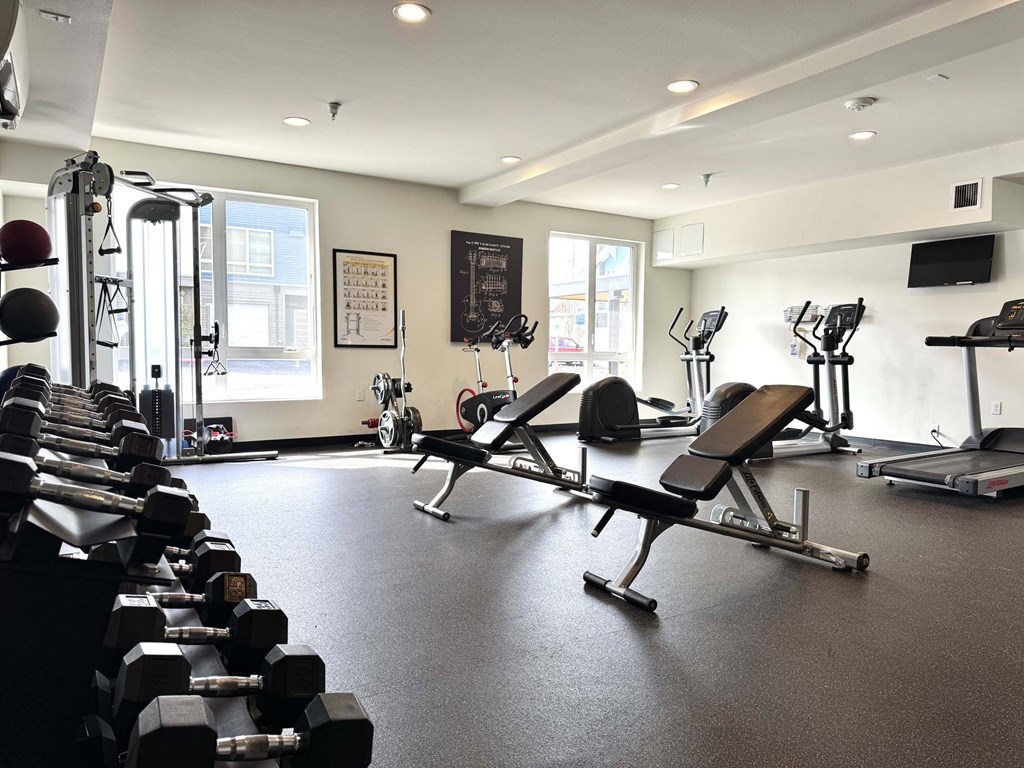 A gym with a variety of equipment including dumbbells, benches, and treadmills. A gym with a variety of equipment including dumbbells, benches, and treadmills at Spyglass Hill Apartments, Bremerton, 98337