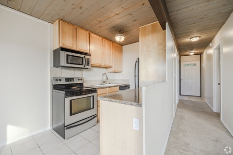 A kitchen with a stove top oven and microwave above it.