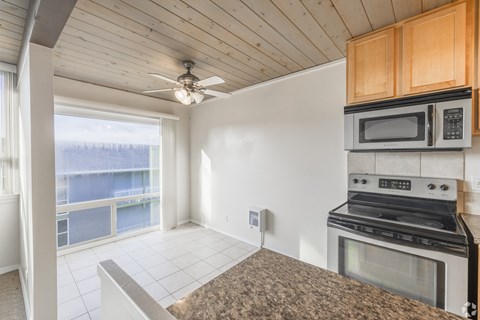 A kitchen with a stove, microwave, and oven.