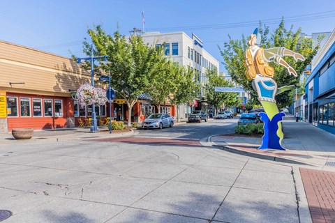 A large blue and yellow sculpture of a person is in the middle of a street  at Spyglass Hill Apartments, Bremerton, 98337