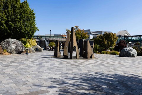 A park with a large rock and a bridge in the background at Spyglass Hill Apartments, Bremerton, 98337