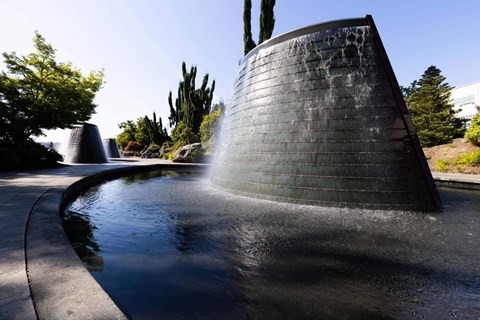 A water feature in a park with a tall, black, cylindrical structure  at Spyglass Hill Apartments, Bremerton, 98337