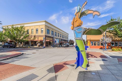A large, colorful sculpture of a bird is situated in the middle of a city square  at Spyglass Hill Apartments, Bremerton, 98337