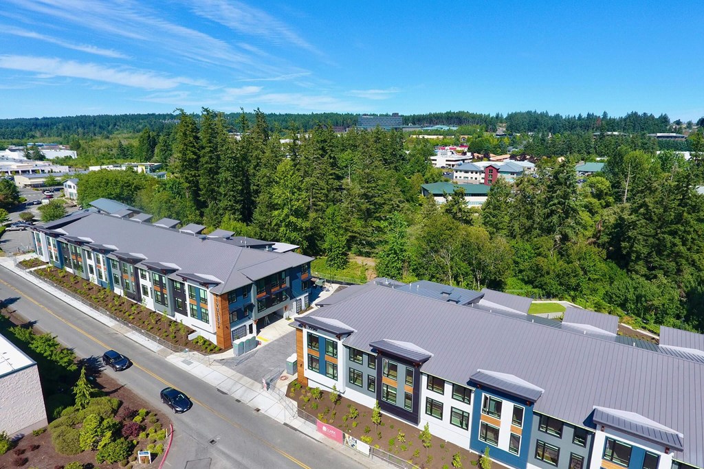 an aerial view of a building with green trees in the background and a road in the foreground at Rivulet, Silverdale Washington
