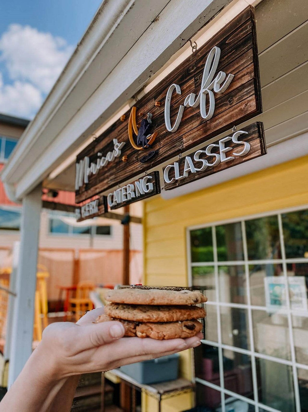 a hand holding a sandwich in front of a building at Rivulet, Silverdale, 98383