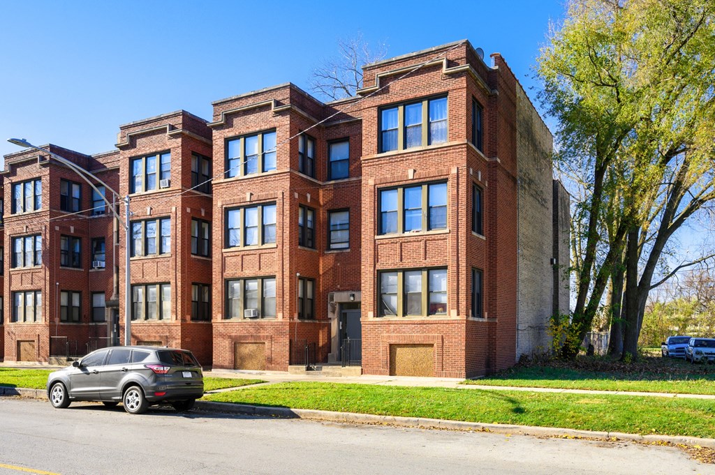 a large brick building with a car parked in front of it