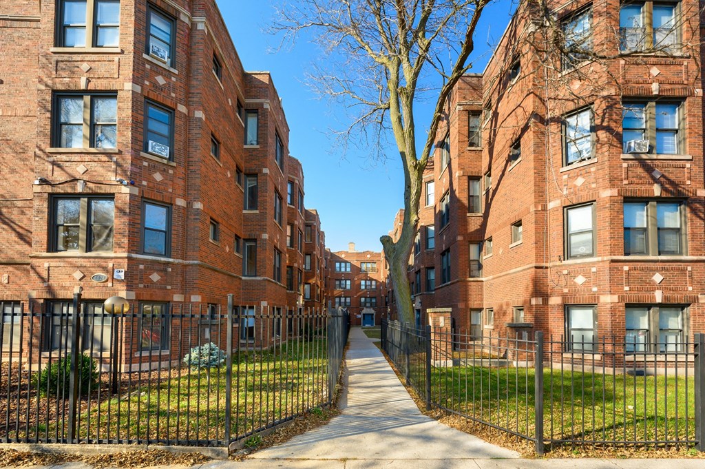 a row of red brick apartment buildings on a sidewalk