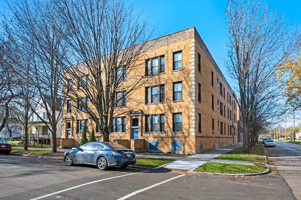 a brick apartment building with a car parked in front of it