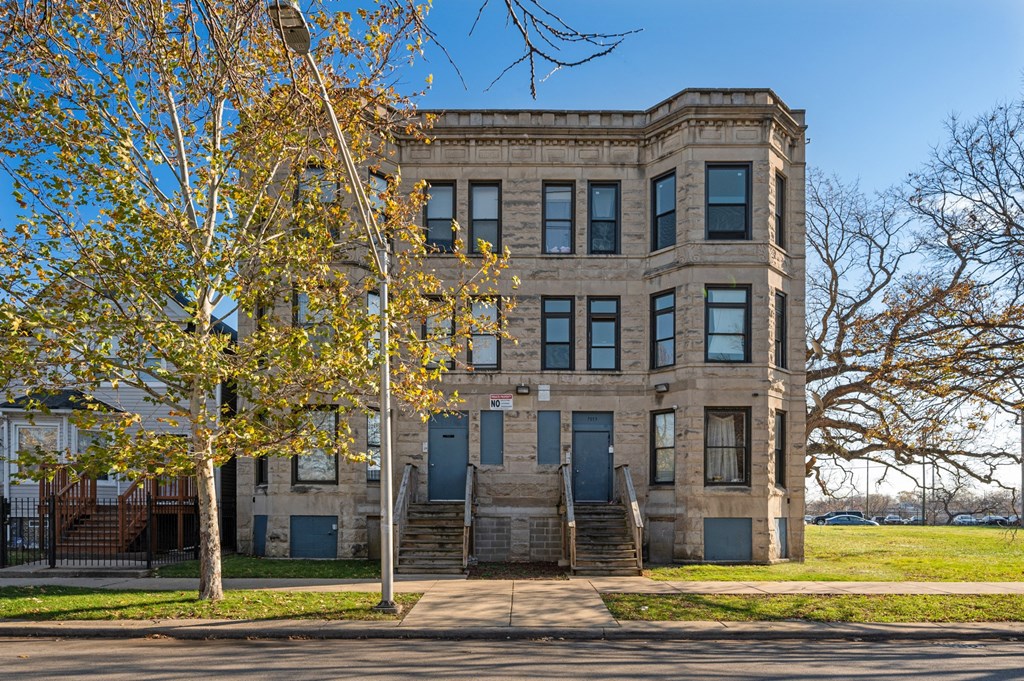 an old building with stairs and trees in front of it