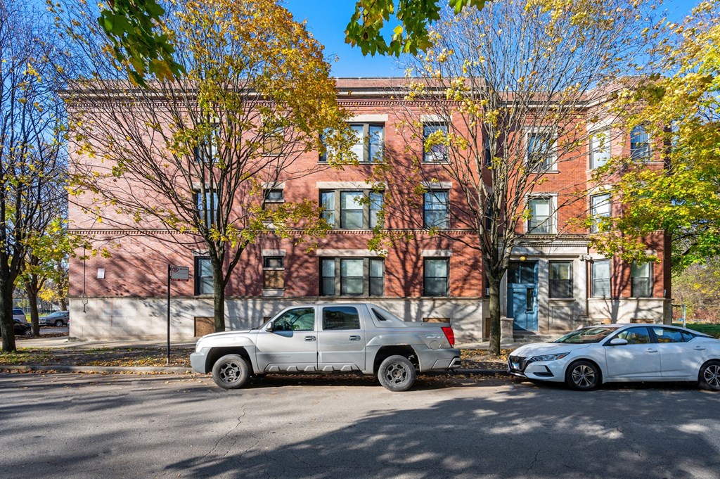 a red brick building with two cars parked in front of it