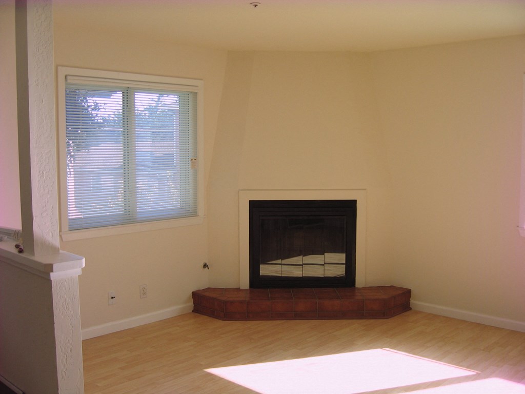 a living room with a fireplace and a window