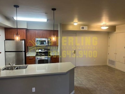 A kitchen with a counter and a fridge.