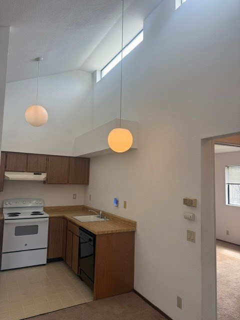 A kitchen with a white stove and wooden cabinets.