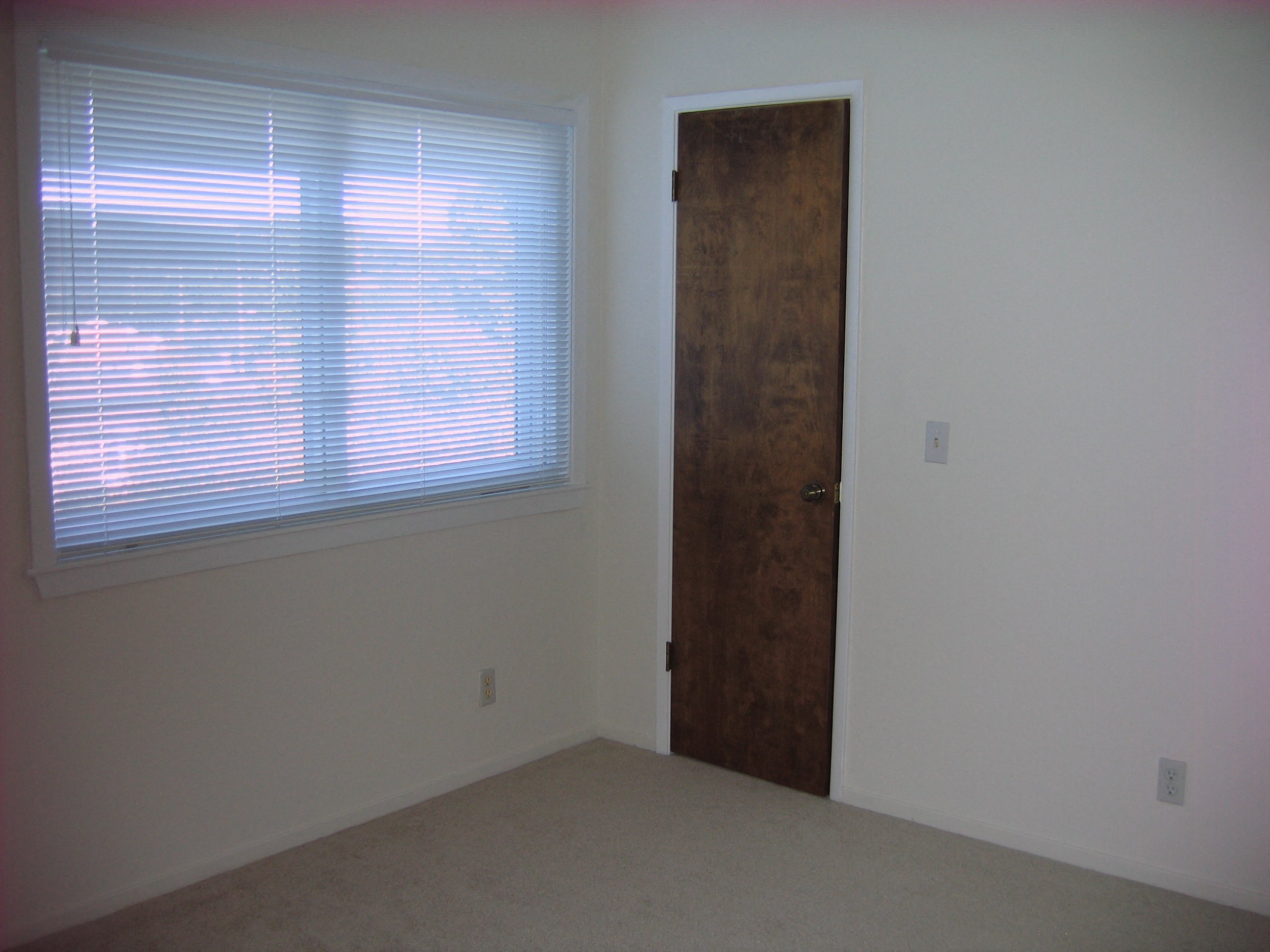 an empty room with a window and a door