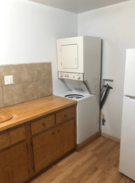 A kitchen with a white fridge, white oven, and a white microwave.