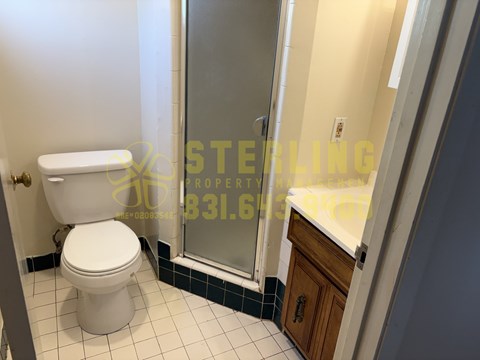 A white toilet in a bathroom with a glass shower door.