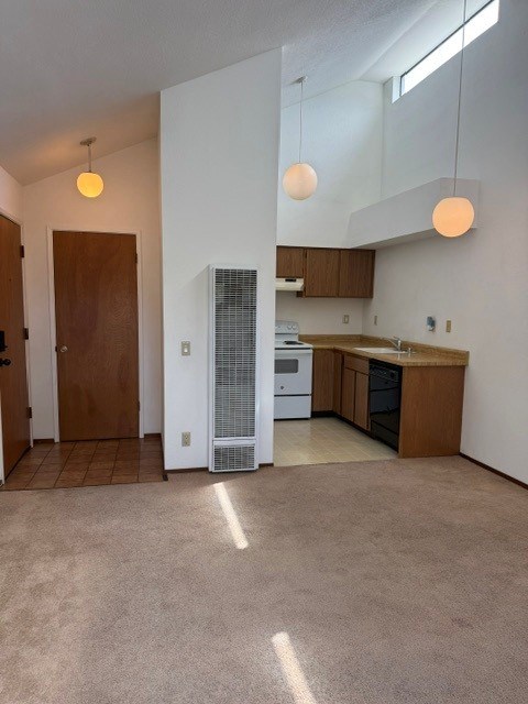 A kitchen with a refrigerator, oven, and cabinets.