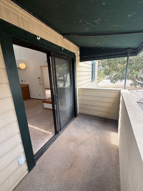 A patio area with a sliding glass door and a small table and chairs inside.
