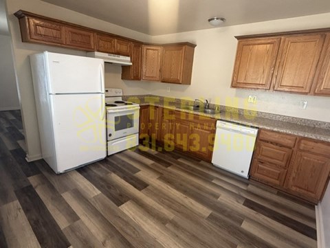 A kitchen with a white fridge and wooden cabinets.