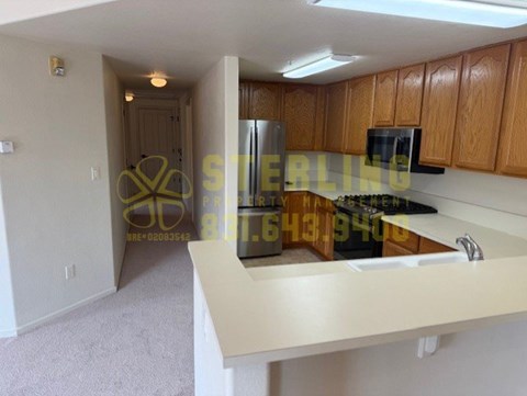 A kitchen with wooden cabinets and a white countertop.