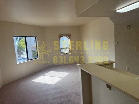A room with a carpeted floor and a window with blinds.