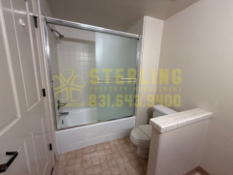A bathroom with a toilet and a glass shower door.