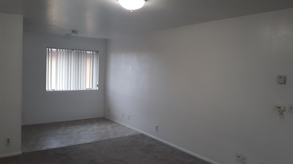 A room with a window and a ceiling light.