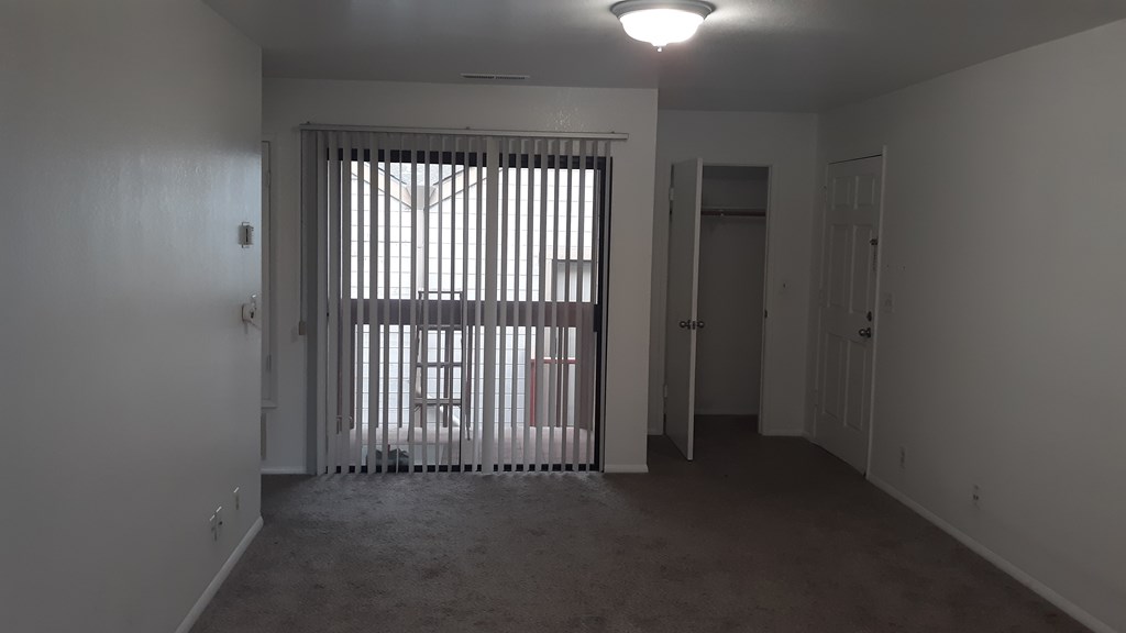 A room with a window covered by bars.