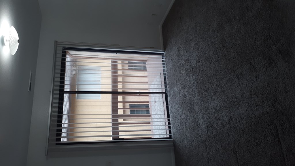 A window with blinds is open, letting in a soft light.