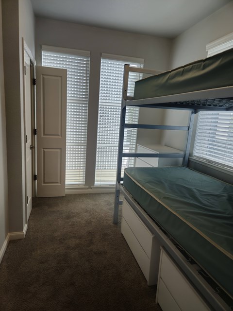 A bedroom with a bunk bed and a door.