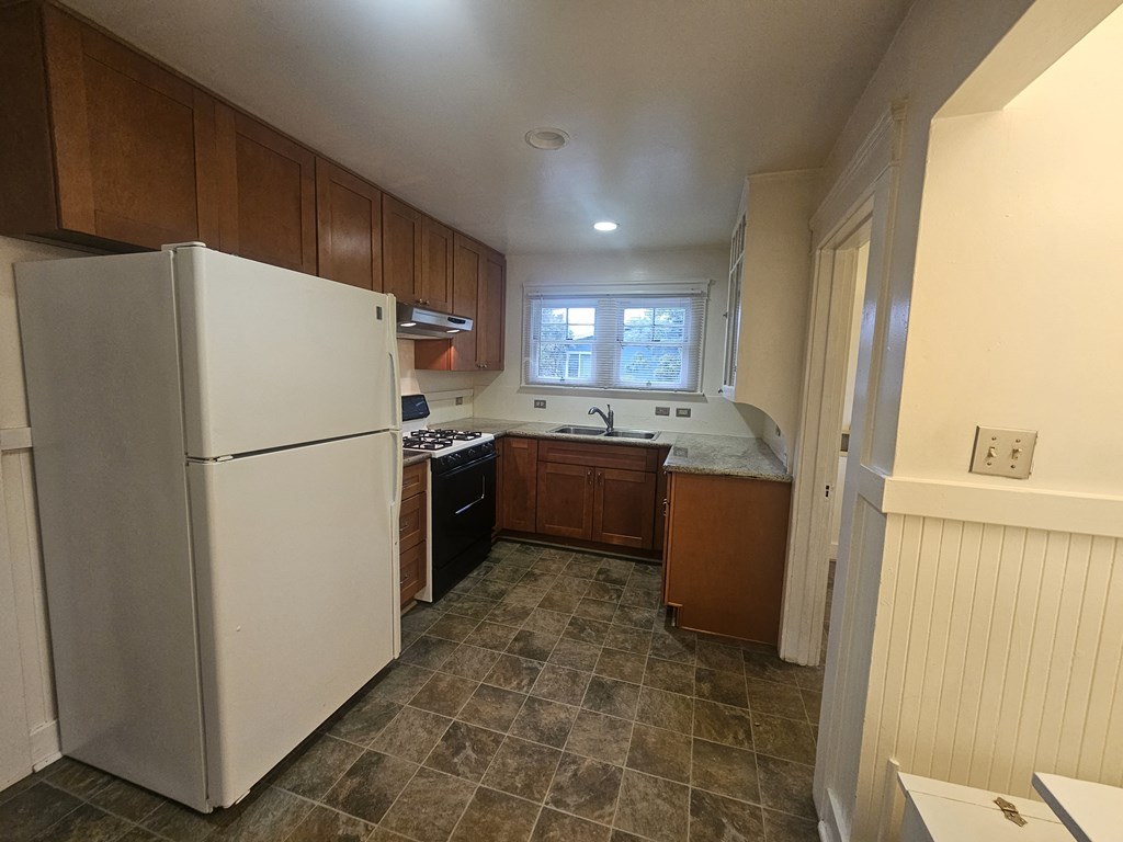 a kitchen with white appliances and wooden cabinets