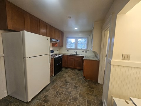 a kitchen with white appliances and wooden cabinets