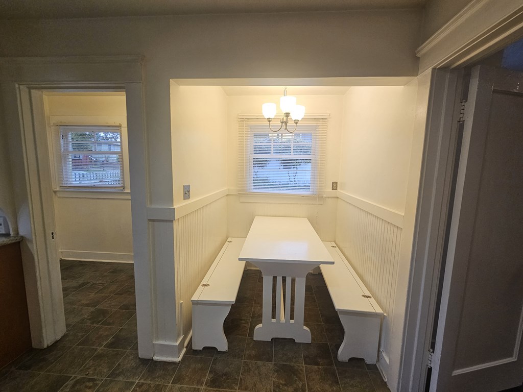 a dining room with a white table and benches