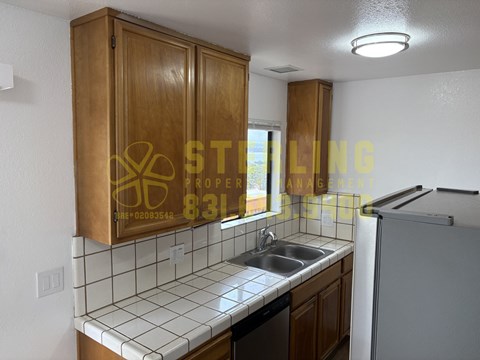 A kitchen with wooden cabinets and a white tiled backsplash.